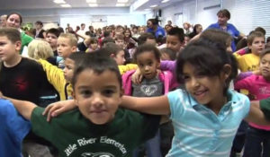 Children with their arms around each other at a school assembly