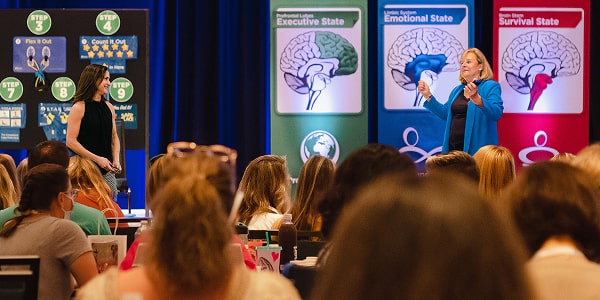 Becky on stage with banners